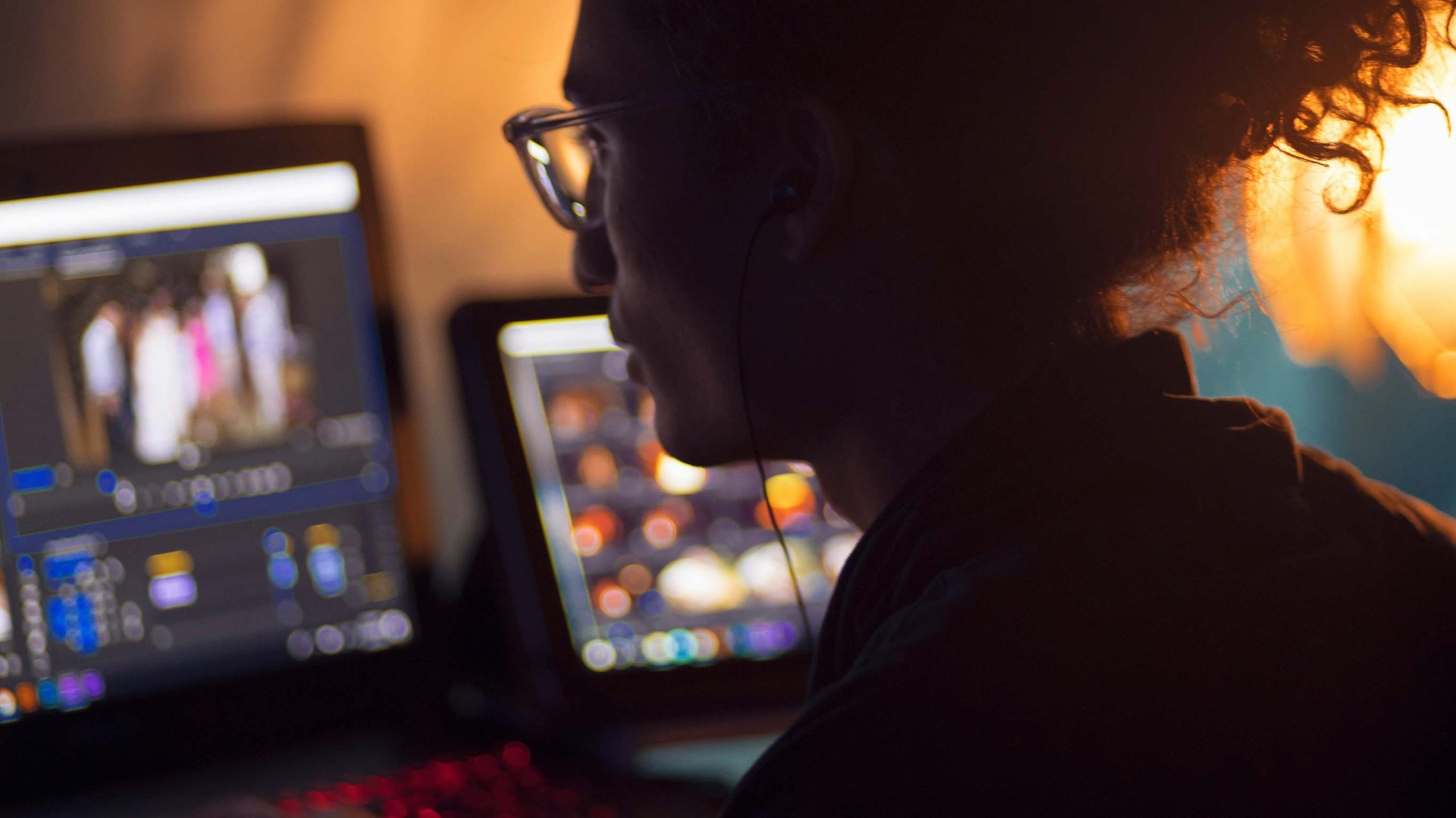 En person sitter bakom en laptop och arbetar i ett redigeringsprogram för video.